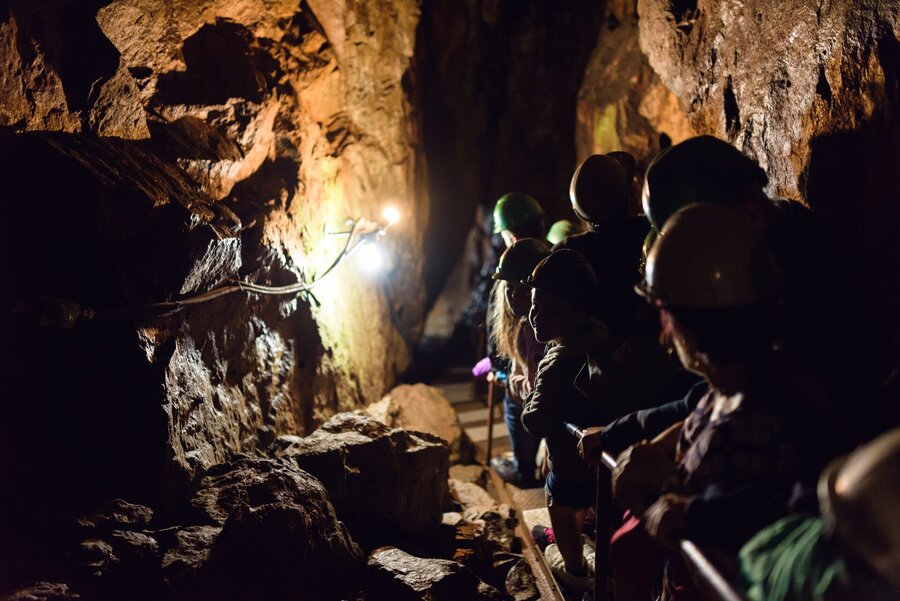 Groupe de personnes en visite dans une grotte à la Caverne trou de la fée