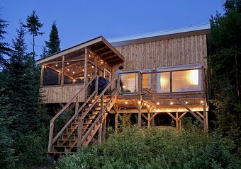 Copilot said:  Chalet sur pilotis illuminé en forêt au crépuscule à Malherbe