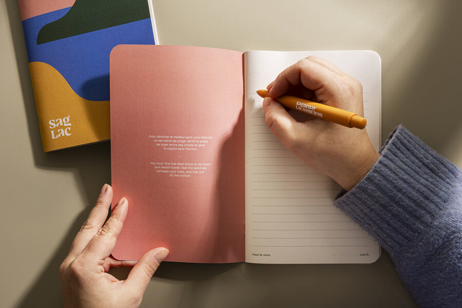 Main écrivant dans un carnet avec crayon SagLac 