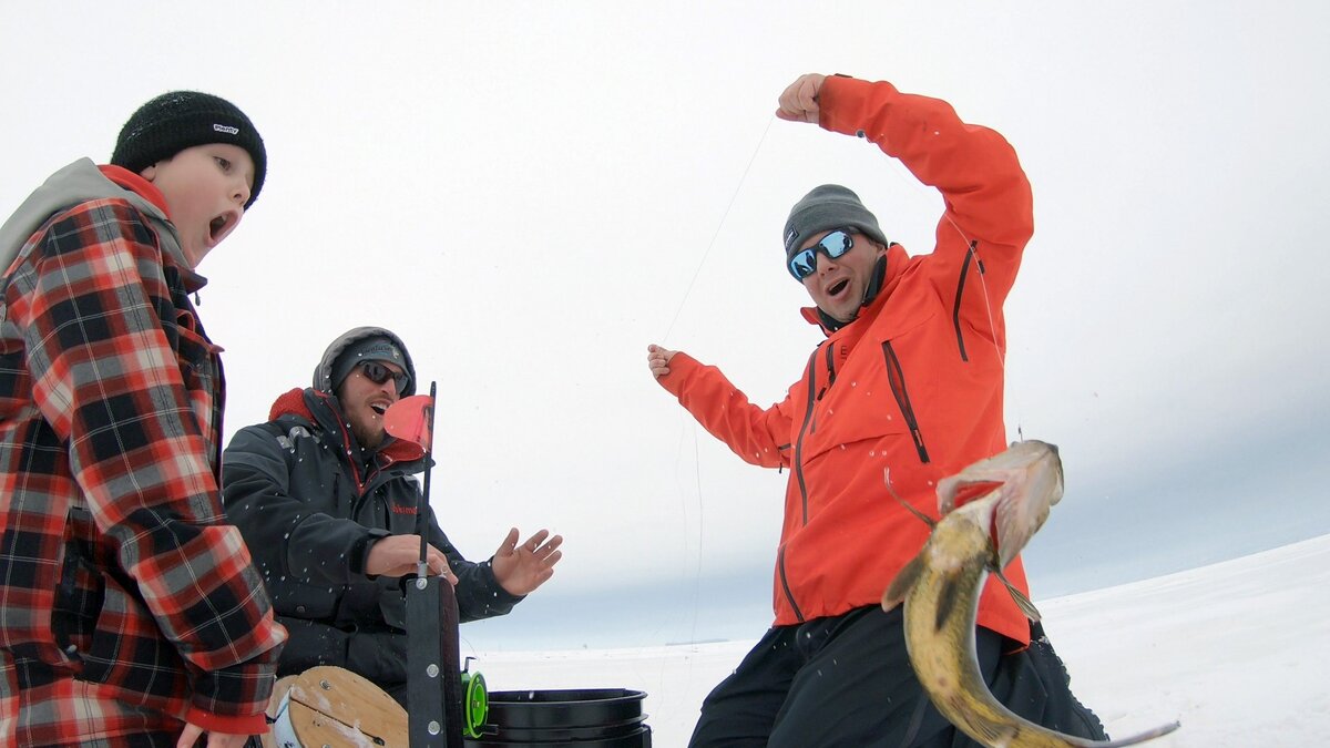 Group of ice fishermen having caught a fish