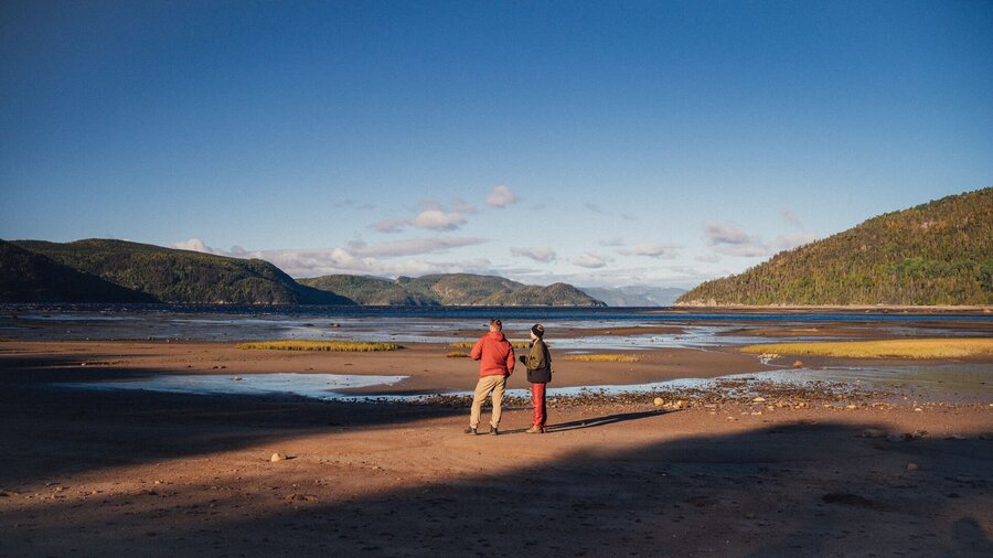 Deux personnes marchant sur les battures du fjord du Saguenay