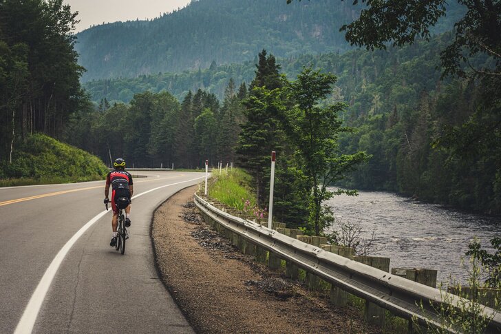 Cycliste sur la Véloroute du Fjord longeant une rivière