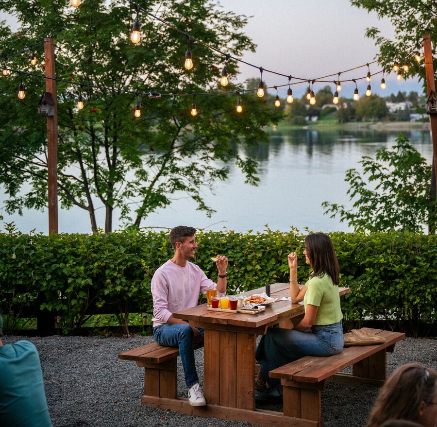 Couple dégustant des bières en terrasse au bord de l’eau