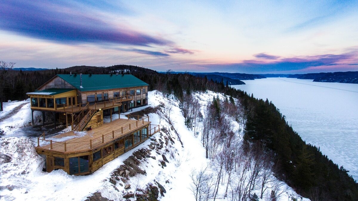 Aerial view of the main chalet of the Pourvoirie du Cap-au-Leste in winter