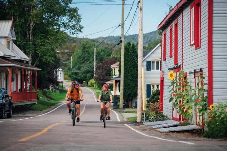Deux cyclistes sur la Véloroute du Fjord dans un village coloré