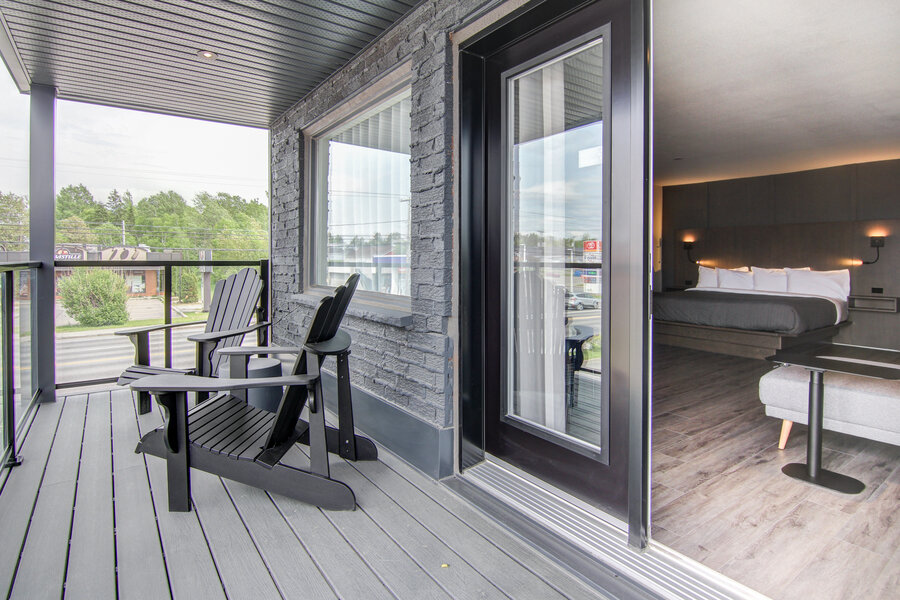 Chambre moderne avec balcon privé et fauteuils extérieurs