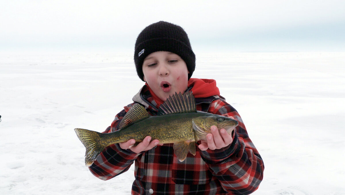 Young ice fisherman with a cod