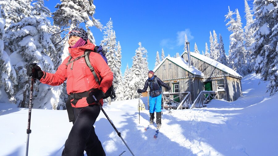 Randonneur en ski de fond quittant un chalet sur les Monts-Valin