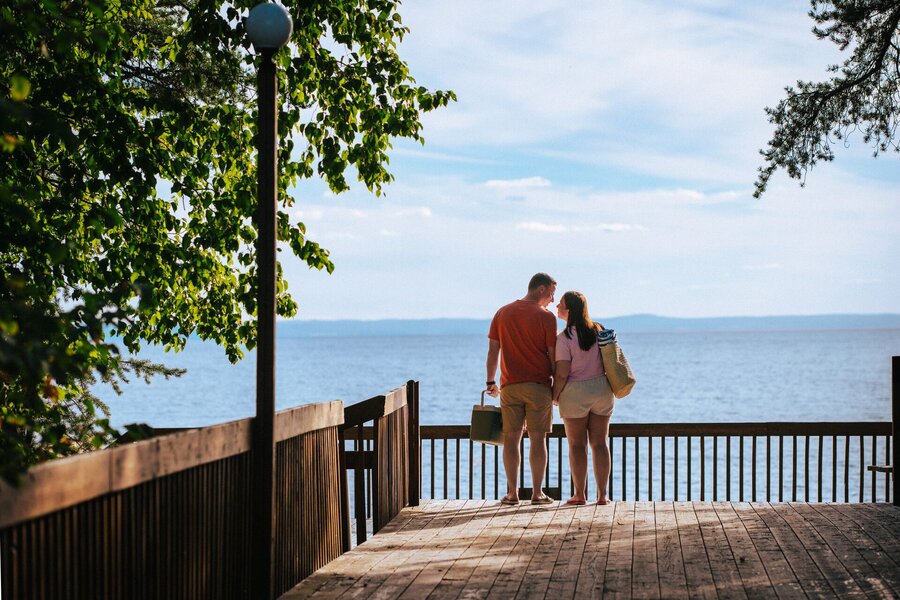 Couple standing on a wooden deck overlooking lake Saint-Jean