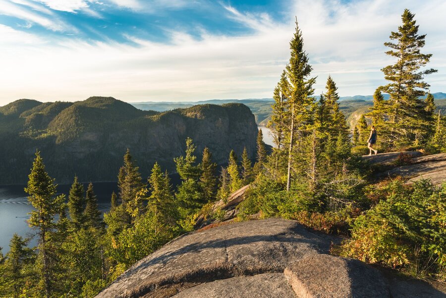 Randonneur admirant le fjord du Saguenay depuis un sommet rocheux