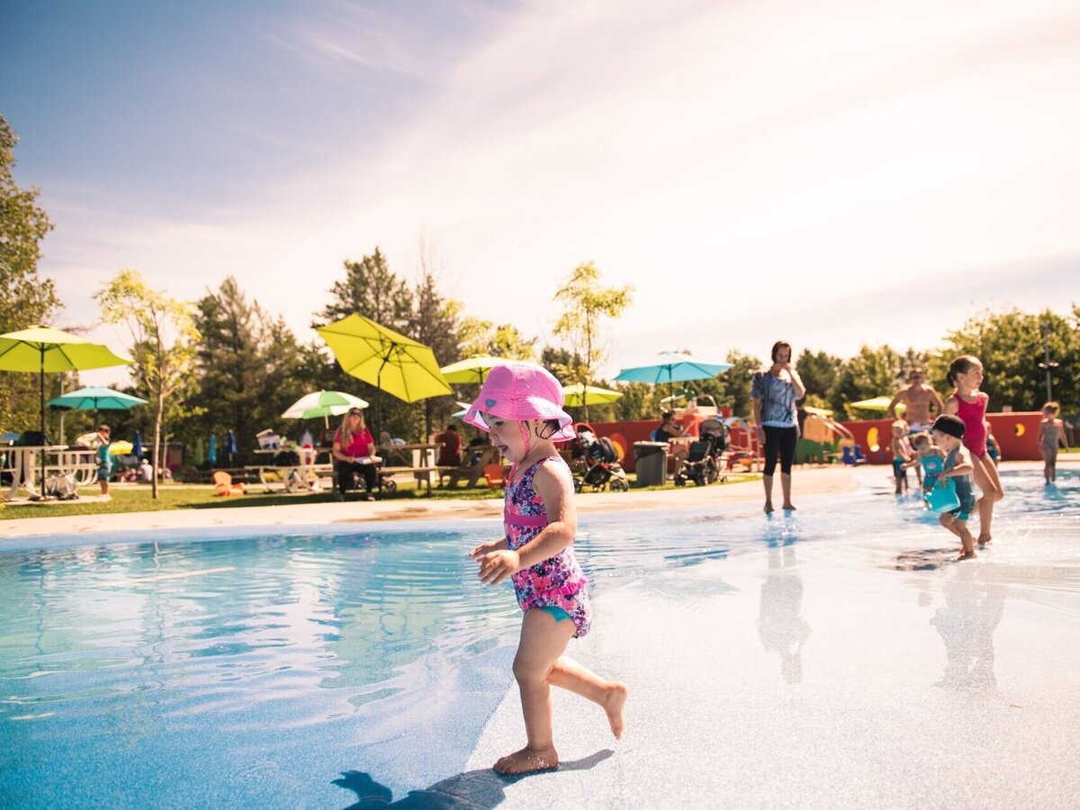 Enfants qui jouent dans les jeux d'eau lors d'une journée ensoleillée.