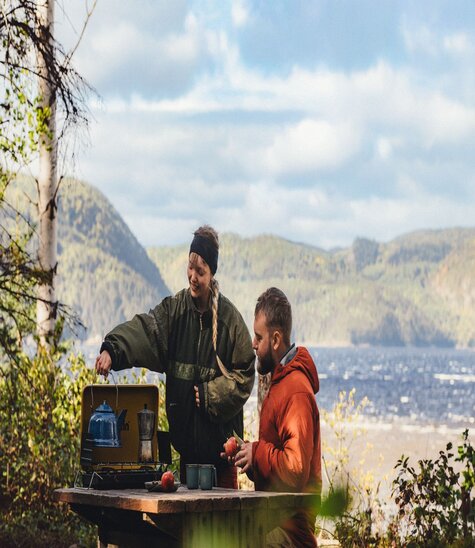 Deux campeurs cuisinent en bordure du fjord du Saguenay