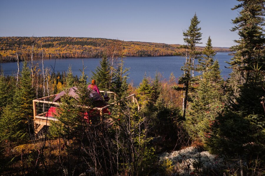 Tent platform overlooking a forest lake in autumn