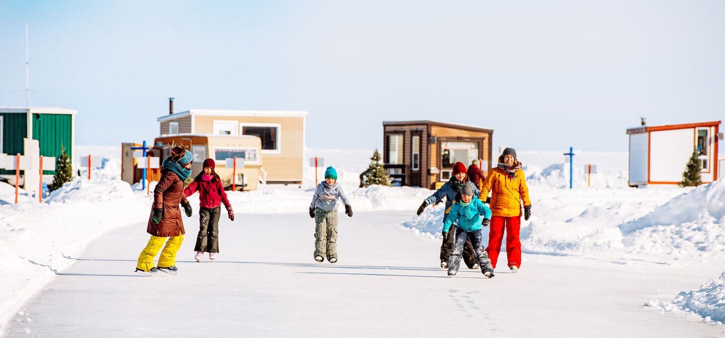 Enfants patinant sur une glace extérieure au Village de glace de Robervalen hiver