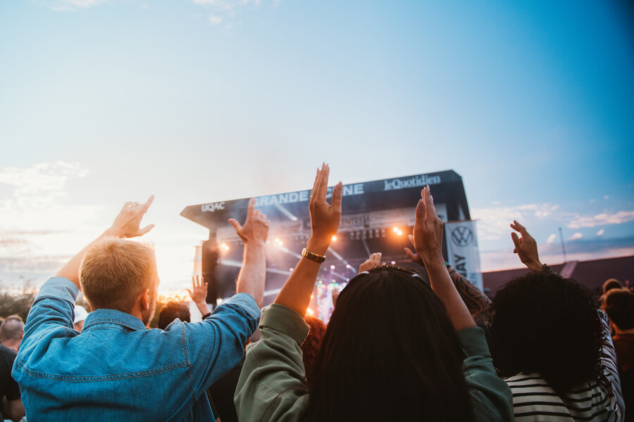 Foule levant les mains devant une scène de festival