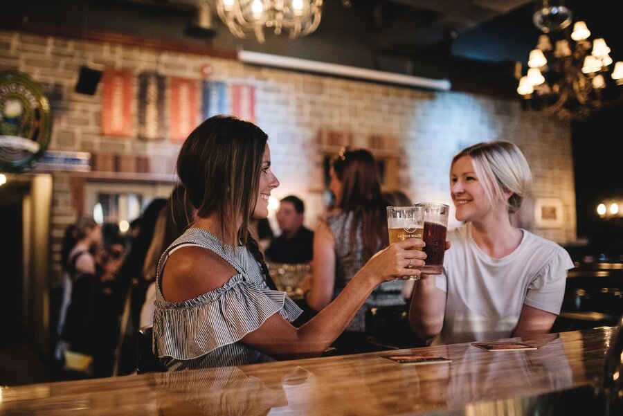 Deux personnes levant leur verre dans une microbrasserie