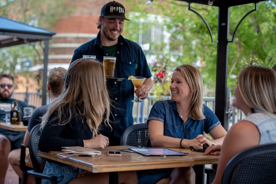 Serveur apportant des boissons à des clients en terrasse