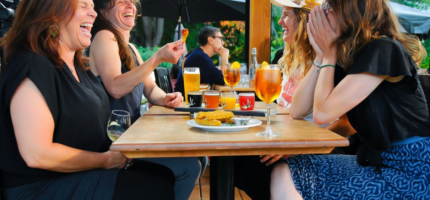 Groupe dégustant bières et repas sur une terrasse