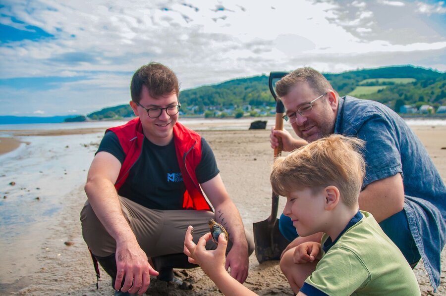 Enfant découvrant un coquillage avec le Musée du Fjord