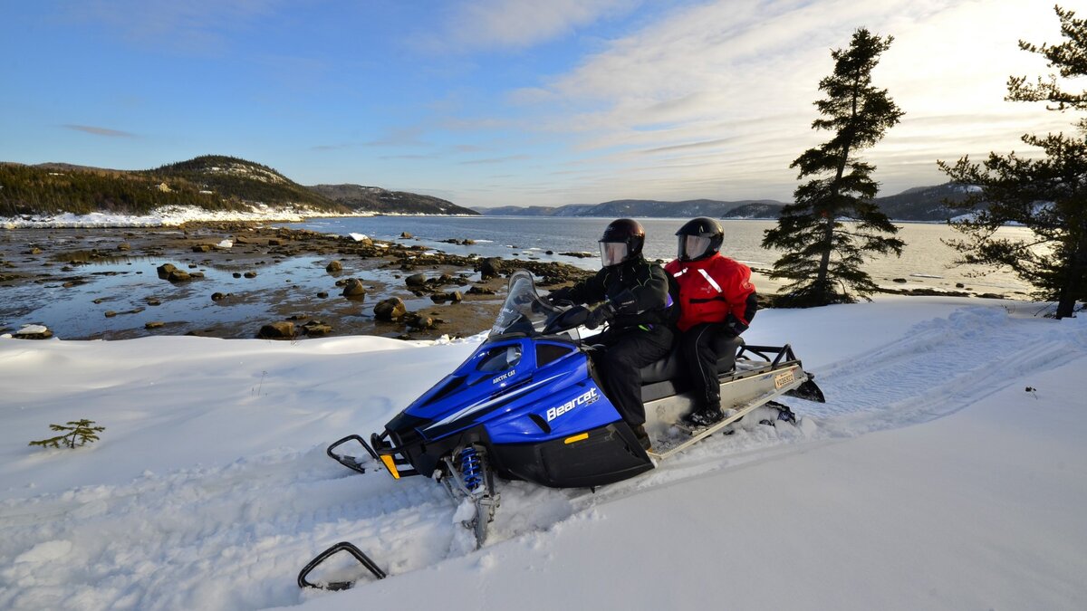 Couple en motoneige sur le bord du Saguenay