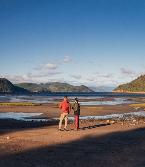 Campers walking with coffee by the Saguenay Fjord