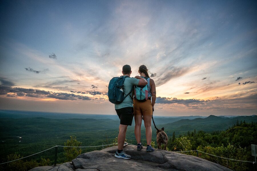 Couple avec leur chien au sommet de la randonnée