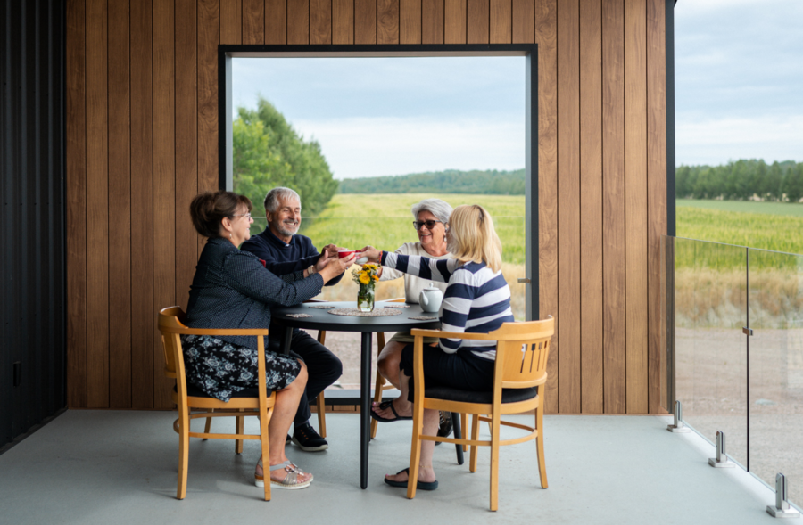 Groupe attablé sur une terrasse avec vue sur les champs