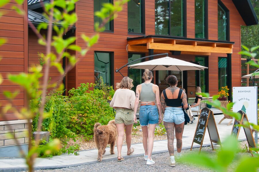 Visiteurs et chien devant la Distillerie du Fjord 