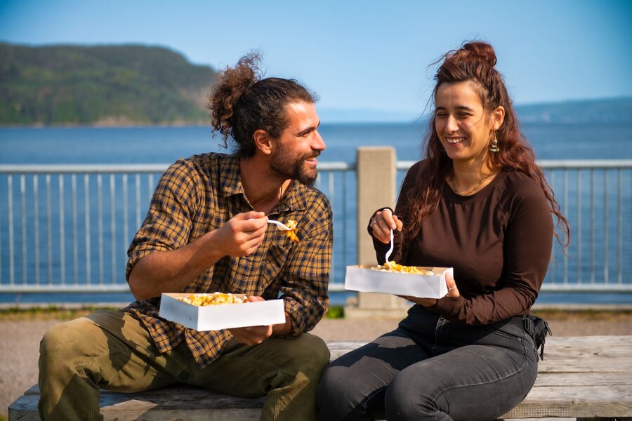 Deux personnes dégustant un repas avec vue sur le fjord