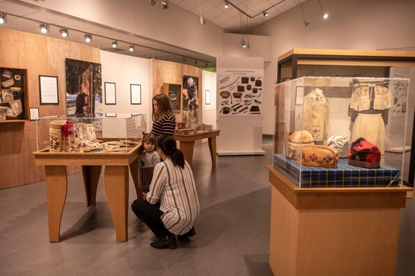 Maman avec ses enfants dans une exposition du Musée Ilnu de Mashteuiatsh